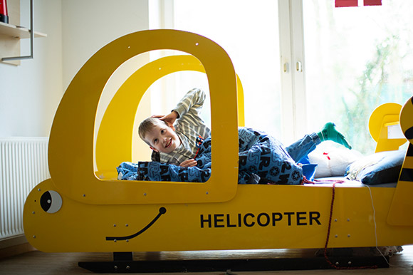 Ein Junge in einem Bett, das wie ein Hubschrauber aussieht