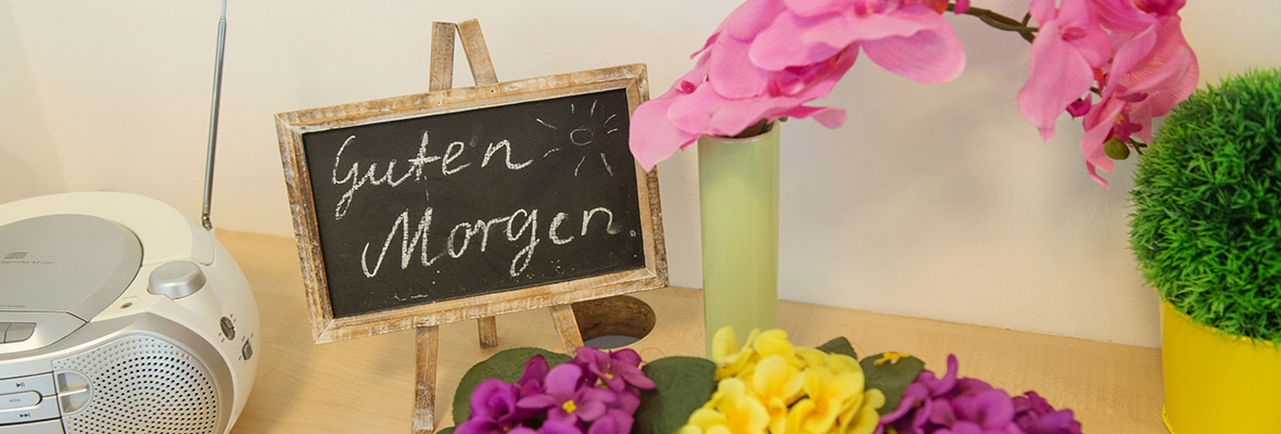 Ein Tisch mit Blumen dekoriert und einer kleinen Tafel auf der "Guten Morgen" steht
